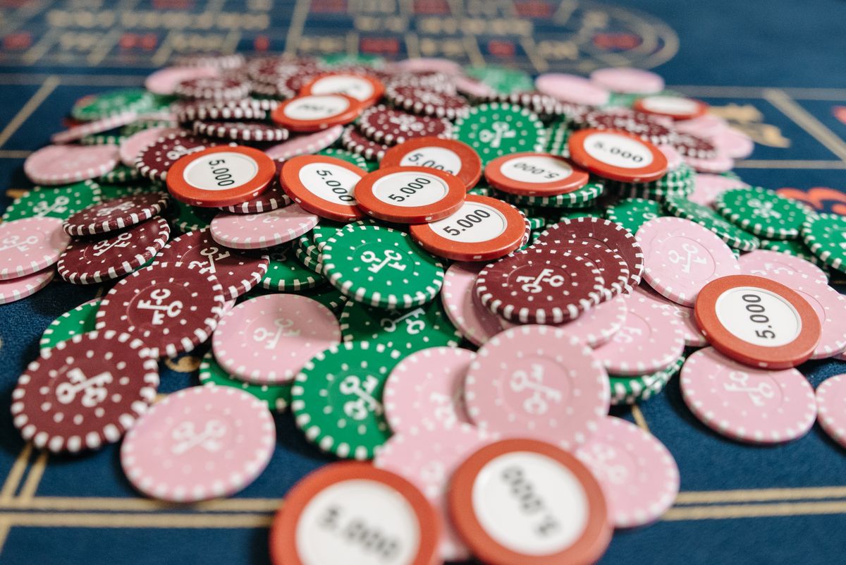 Pile of colourful casino chips on a betting table, representing casino-style slots and table games
