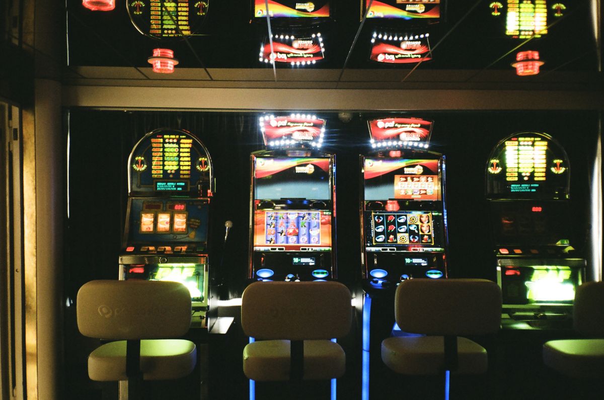 Row of illuminated online slot machines with colourful reels in a South African casino
