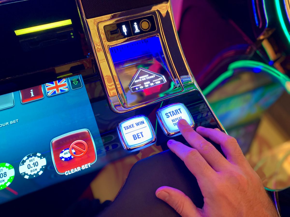 Close-up of a slot machine's bet, start and take-win buttons illustrating how online slot game controls work